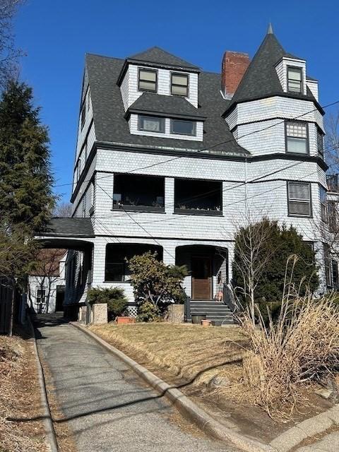 victorian-style house with an attached carport and brick siding