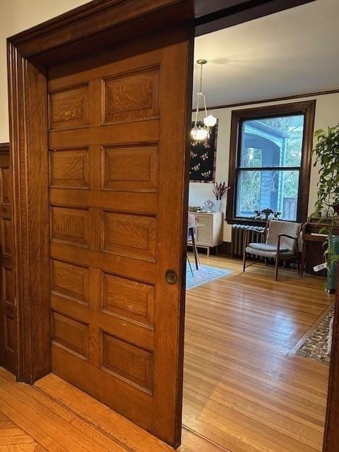 interior space featuring radiator heating unit, light wood-style flooring, and an inviting chandelier