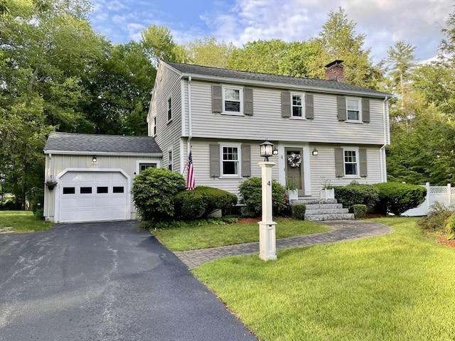 4 Hickory Ln, North Reading, MA 01864 - colonial house featuring a chimney, a garage, asphalt driveway, and a front yard