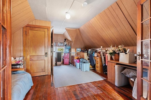 interior space with lofted ceiling, dark wood-type flooring, and wooden walls