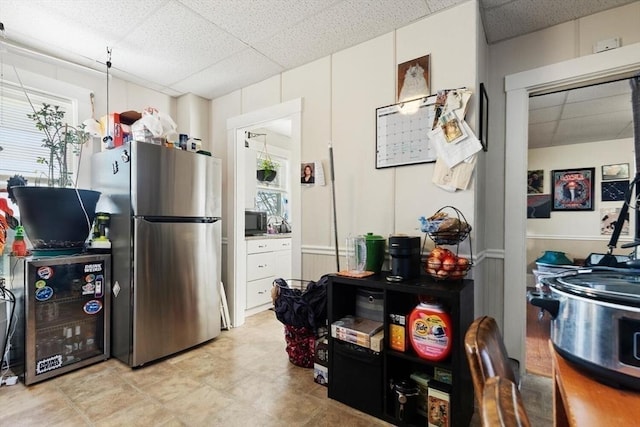 kitchen featuring stainless steel fridge and a drop ceiling