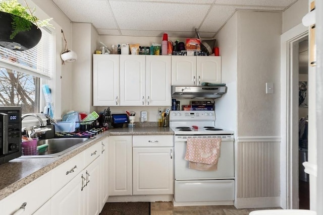 kitchen featuring electric stove, sink, a paneled ceiling, and white cabinets