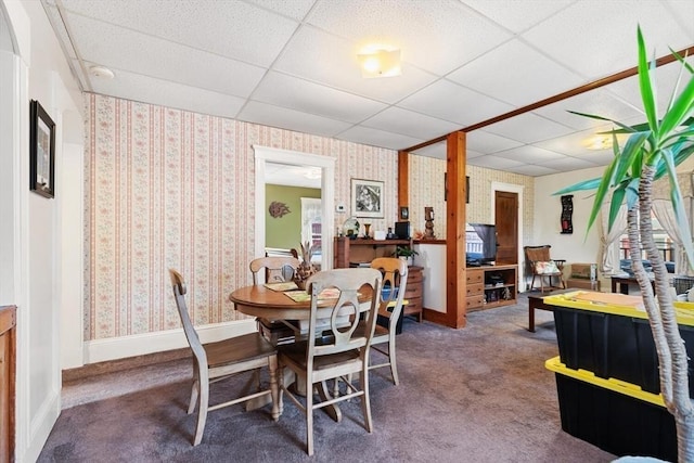 dining area featuring a paneled ceiling and dark carpet