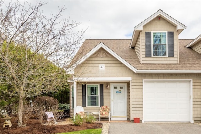 view of front of home with a garage, a shingled roof, and aphalt driveway