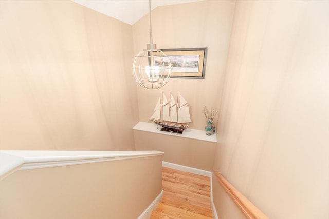 hall featuring light wood-style floors and a notable chandelier