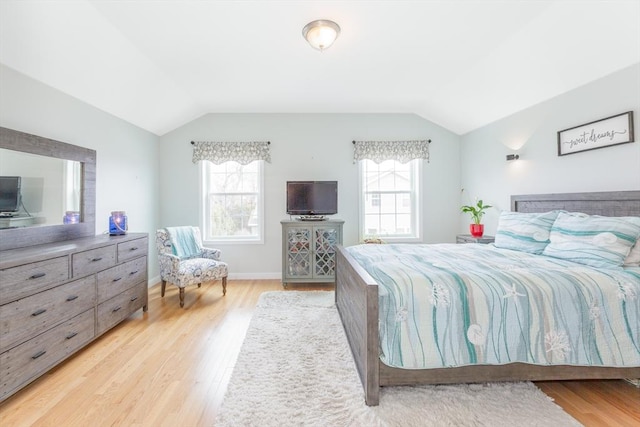 bedroom with light wood finished floors and vaulted ceiling