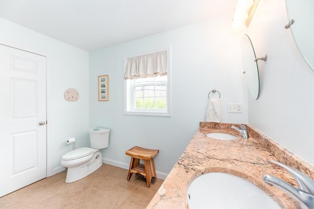 full bathroom featuring a sink, baseboards, toilet, and double vanity