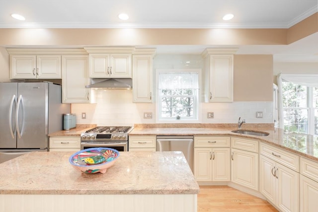 kitchen with a sink, cream cabinetry, and stainless steel appliances