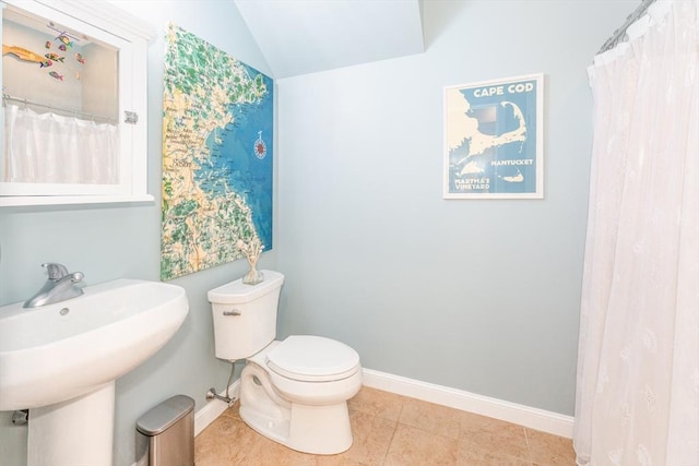 full bathroom featuring tile patterned flooring, lofted ceiling, toilet, baseboards, and a sink