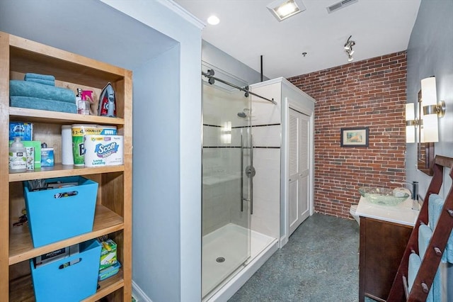 bathroom featuring visible vents, vanity, brick wall, and a shower stall