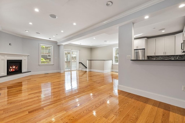 20 Winfield St Unit 1, Boston, MA 02127 - unfurnished living room featuring ornamental molding, light wood-style flooring, a glass covered fireplace, and recessed lighting