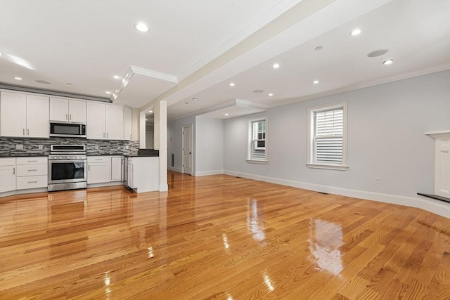 20 Winfield St Unit 1, Boston, MA 02127 - kitchen featuring appliances with stainless steel finishes, ornamental molding, open floor plan, dark countertops, and tasteful backsplash