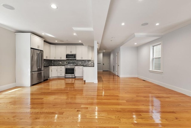 20 Winfield St Unit 1, Boston, MA 02127 - kitchen with stainless steel appliances, open floor plan, decorative backsplash, crown molding, and white cabinetry