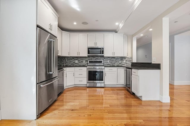 20 Winfield St Unit 1, Boston, MA 02127 - kitchen with appliances with stainless steel finishes, dark countertops, tasteful backsplash, light wood-style floors, and recessed lighting
