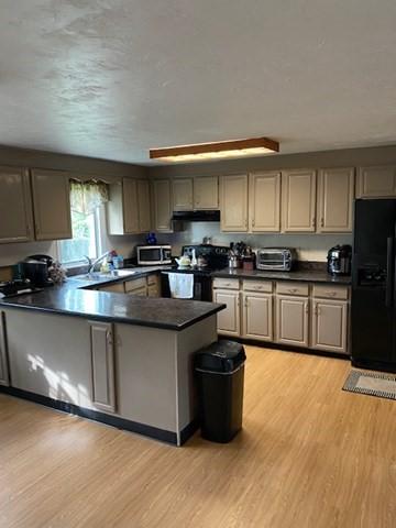 19 Camelot Ct Unit 19, Stoughton, MA 02072 - kitchen with black refrigerator with ice dispenser, stainless steel microwave, dark countertops, and range hood