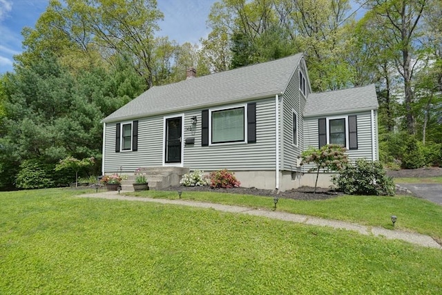 view of front of property featuring roof with shingles and a front yard