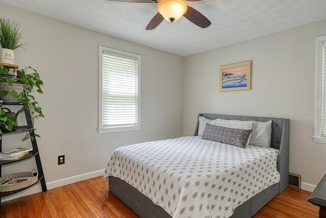 bedroom featuring wood finished floors, baseboards, and ceiling fan