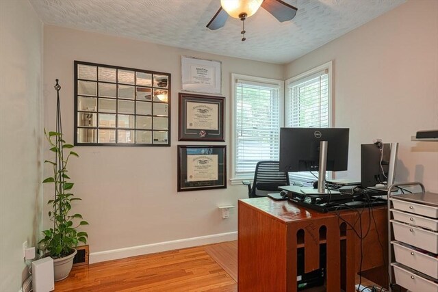 office with ceiling fan, light wood-type flooring, baseboards, and a textured ceiling