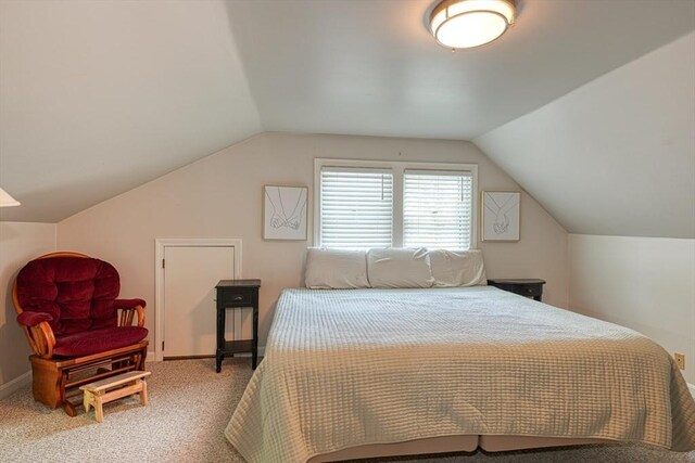 bedroom featuring lofted ceiling, carpet floors, and baseboards