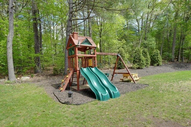 view of play area featuring a yard and a wooded view