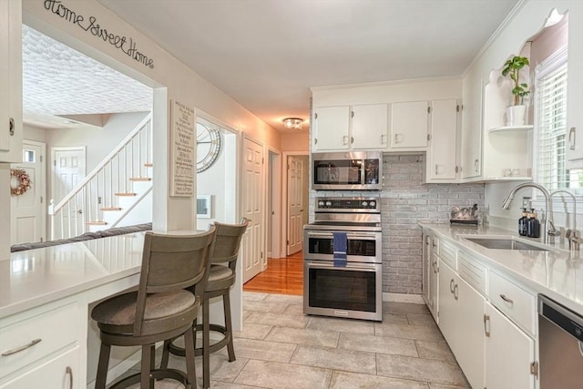 kitchen with appliances with stainless steel finishes, a sink, white cabinets, open shelves, and tasteful backsplash