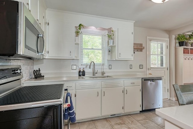 kitchen featuring stainless steel appliances, a sink, open shelves, light countertops, and white cabinets
