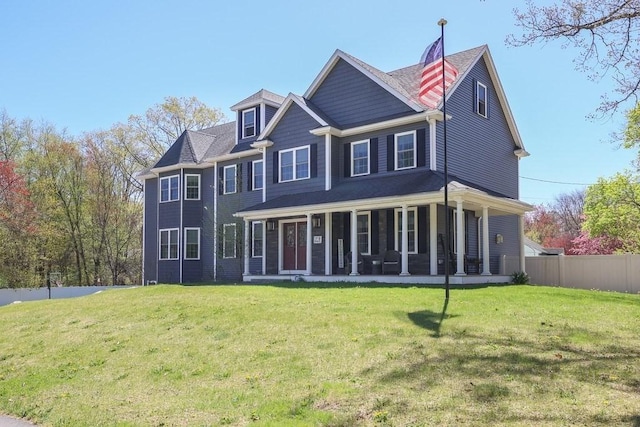 rear view of property featuring a yard, fence, and a porch