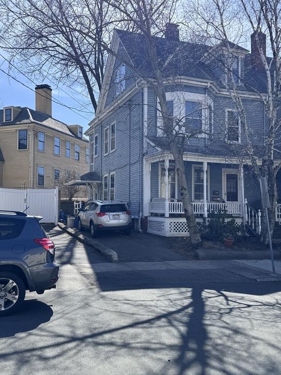 91 Tudor St, Chelsea, MA 02150 - view of front facade featuring a porch and a chimney