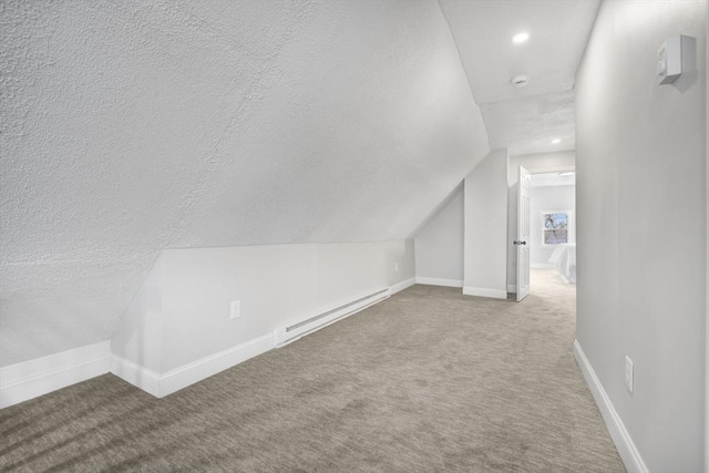 bonus room with lofted ceiling, carpet floors, baseboard heating, and a textured ceiling