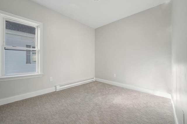 carpeted spare room with a baseboard heating unit