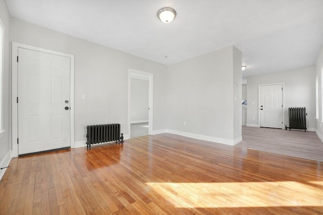 unfurnished living room with hardwood / wood-style flooring and radiator