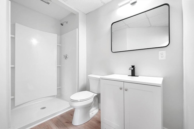 bathroom featuring toilet, a shower, vanity, and hardwood / wood-style floors