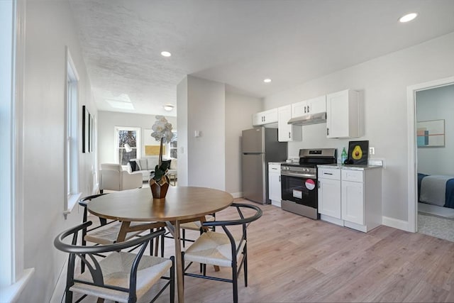 kitchen featuring appliances with stainless steel finishes, light hardwood / wood-style floors, and white cabinets