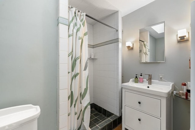 bathroom with a shower stall, vanity, and toilet