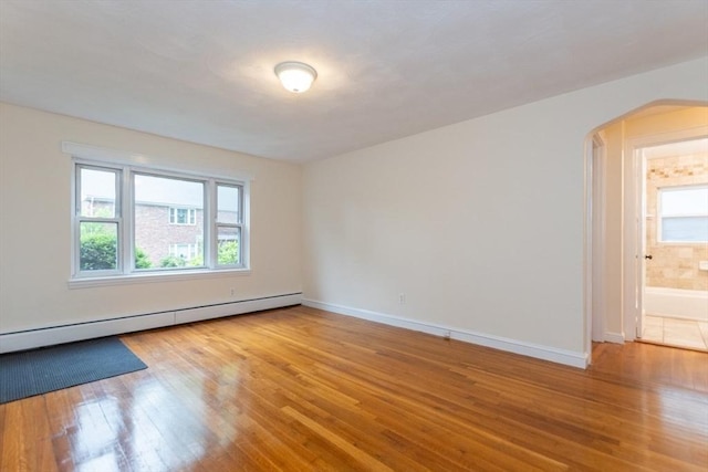 58 Aldrich Rd Unit A, Watertown, MA 02472 - unfurnished room featuring arched walkways, wood finished floors, and a baseboard heating unit