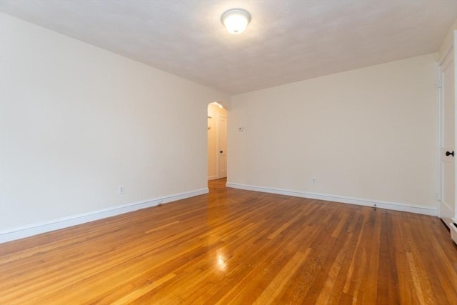 58 Aldrich Rd Unit A, Watertown, MA 02472 - empty room with arched walkways and light wood finished floors