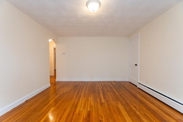 58 Aldrich Rd Unit A, Watertown, MA 02472 - unfurnished room featuring a baseboard radiator, light wood finished floors, and arched walkways