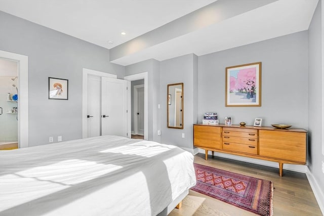 bedroom with wood finished floors and baseboards