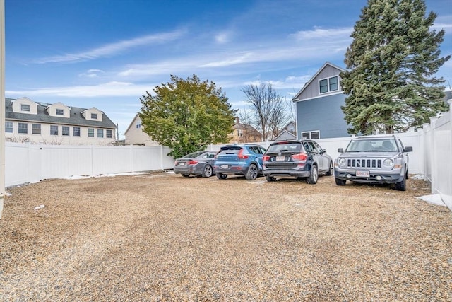 view of parking featuring a residential view and fence