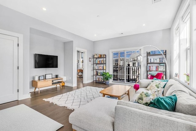 living area featuring dark wood-style floors, baseboards, visible vents, and recessed lighting