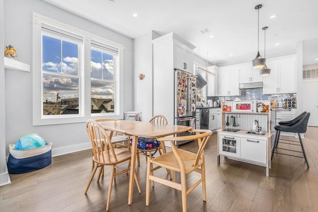 kitchen with stainless steel appliances, light countertops, decorative light fixtures, and white cabinets