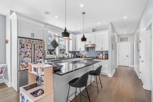 kitchen with a kitchen island, visible vents, white cabinets, open shelves, and dark countertops