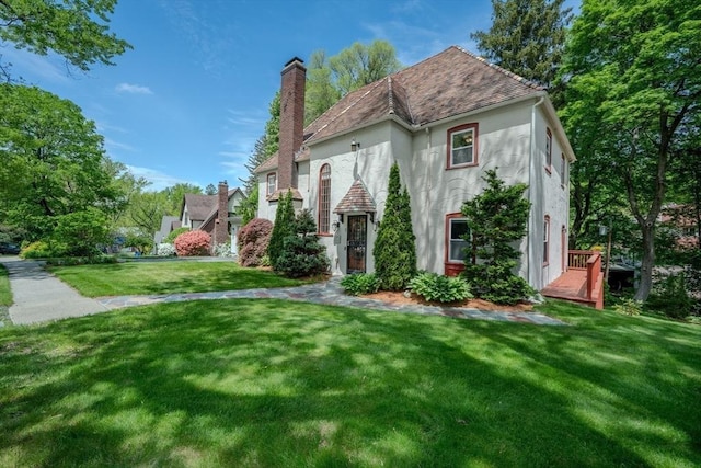 7 Argyle St, Worcester, MA 01609 - view of front of house with stucco siding, a front yard, and a chimney