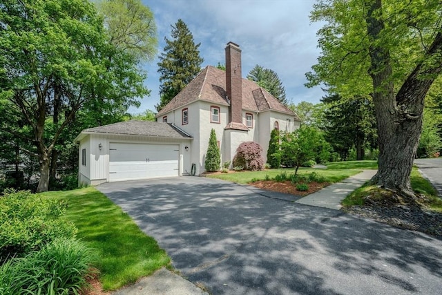 7 Argyle St, Worcester, MA 01609 - view of front of property with stucco siding, asphalt driveway, a chimney, an attached garage, and a front yard