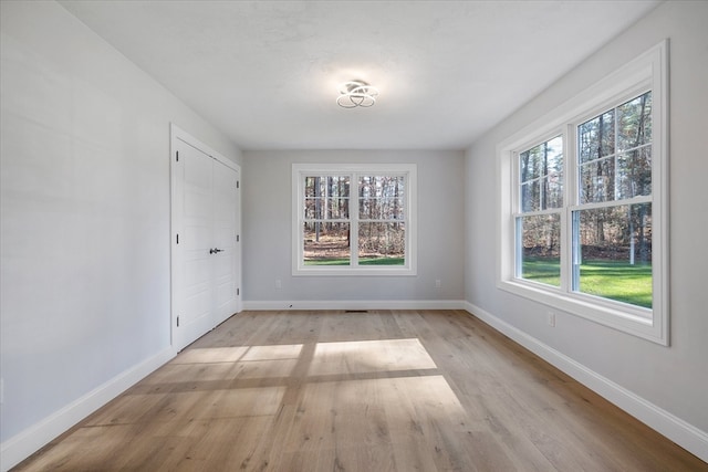 unfurnished room featuring plenty of natural light and light hardwood / wood-style flooring