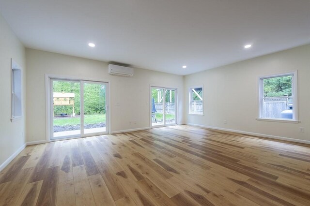 357 Ledge Rd, Seekonk, MA 02771 - unfurnished living room with a wall mounted air conditioner, baseboards, recessed lighting, and light wood-style floors