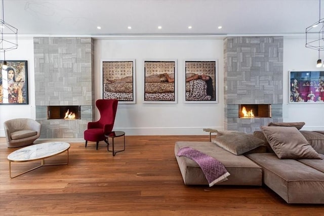 sitting room with recessed lighting, a large fireplace, baseboards, and wood finished floors