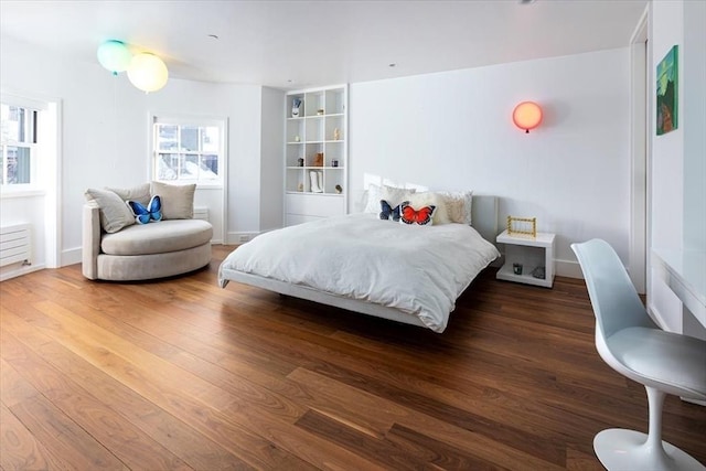 bedroom featuring baseboards and dark wood-style flooring