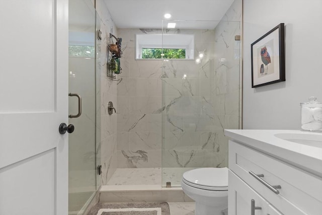 bathroom featuring toilet, a shower with shower door, and vanity