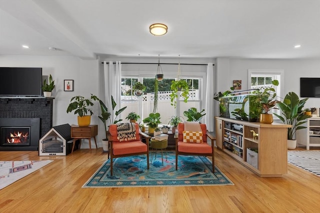 sitting room with a fireplace, hardwood / wood-style floors, and plenty of natural light